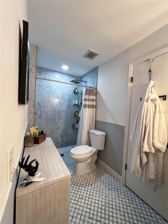 bathroom with a shower with shower curtain and toilet