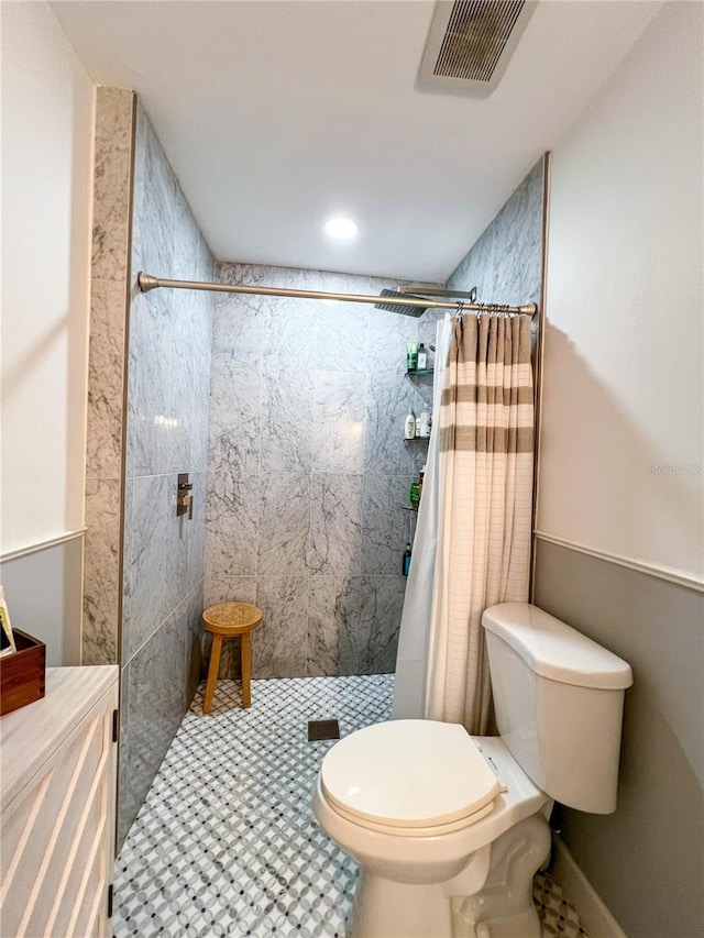 bathroom with tile patterned floors, toilet, and curtained shower