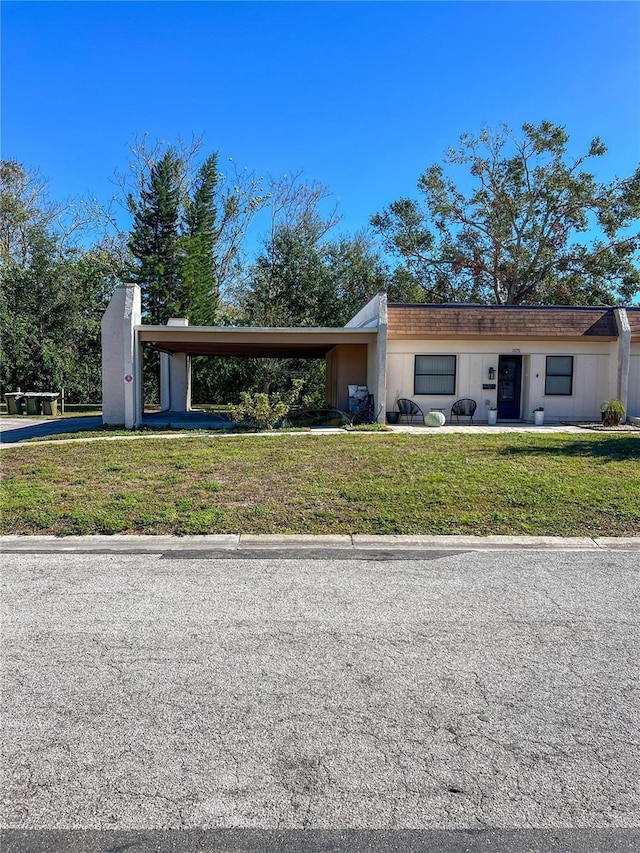 view of front of property featuring a front lawn and a carport