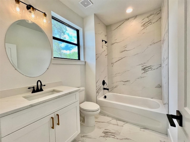 full bathroom featuring vanity, tiled shower / bath combo, and toilet