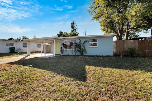 ranch-style house featuring a carport and a front lawn