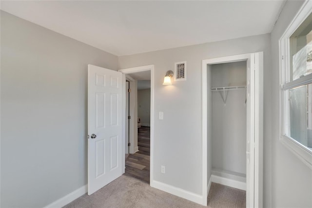 unfurnished bedroom with light carpet and a closet