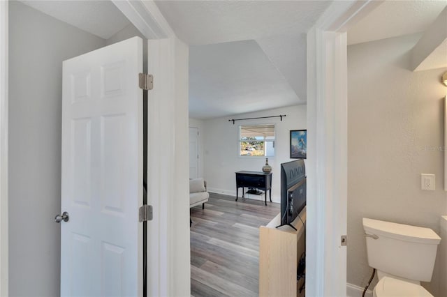 bathroom with toilet and wood-type flooring