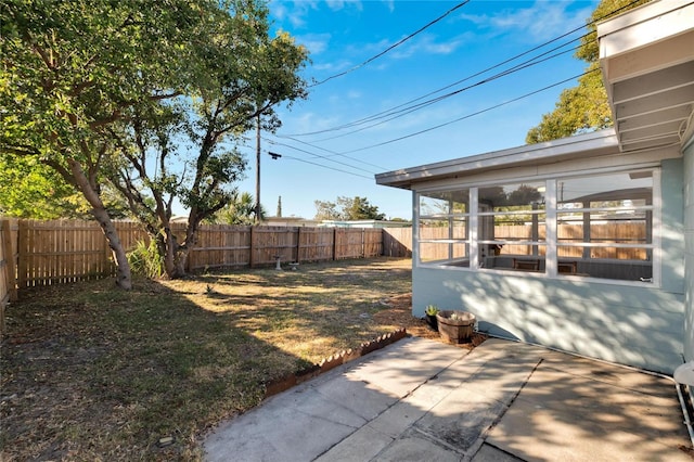 view of yard featuring a sunroom and a patio