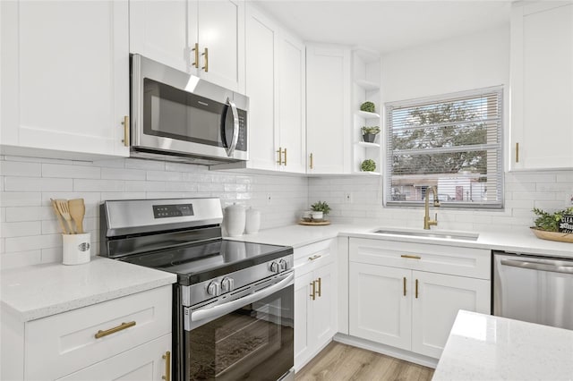 kitchen featuring light stone counters, sink, white cabinetry, and stainless steel appliances