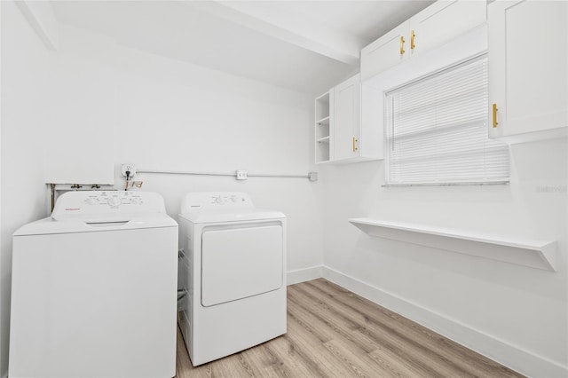 clothes washing area featuring cabinets, independent washer and dryer, and light hardwood / wood-style flooring