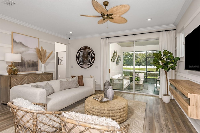 living room with hardwood / wood-style floors, ceiling fan, and ornamental molding