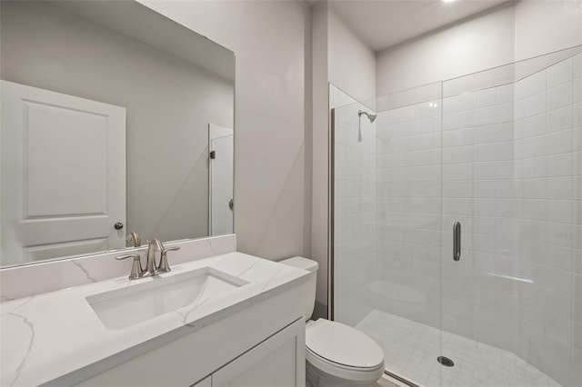 bathroom featuring vanity, toilet, and a shower with shower door