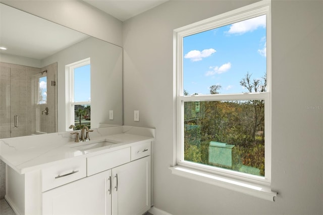 bathroom featuring vanity, a wealth of natural light, and a shower with shower door