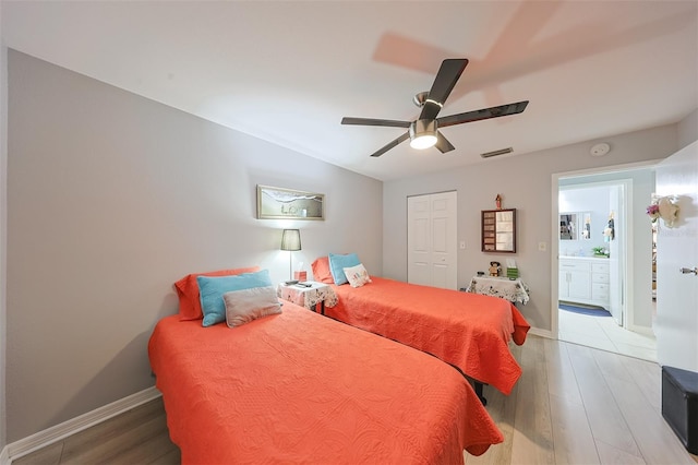 bedroom with hardwood / wood-style floors, ceiling fan, a closet, and ensuite bath