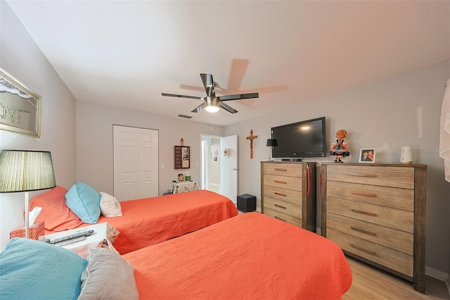 bedroom with ceiling fan, light wood-type flooring, and a closet