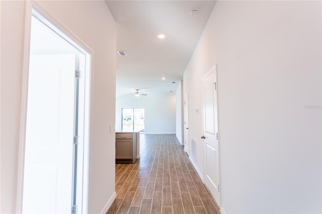 hall featuring light wood-type flooring and vaulted ceiling