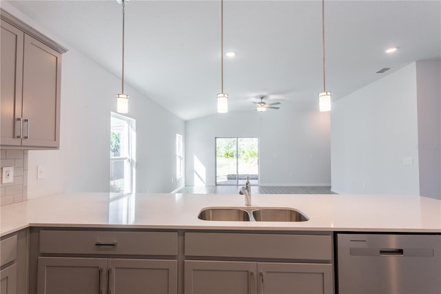 kitchen with tasteful backsplash, stainless steel dishwasher, ceiling fan, sink, and lofted ceiling