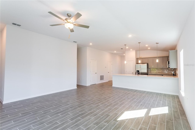 unfurnished living room featuring hardwood / wood-style floors, ceiling fan, and lofted ceiling