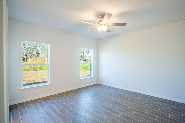 unfurnished room featuring ceiling fan, a healthy amount of sunlight, and dark hardwood / wood-style flooring