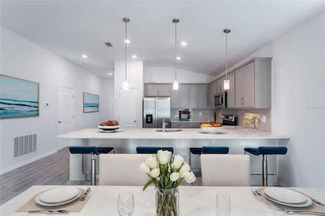 20118 Quesada Ave, Port Charlotte, FL 33952 - kitchen with gray cabinets, appliances with stainless steel finishes, light countertops, tasteful backsplash, and lofted ceiling