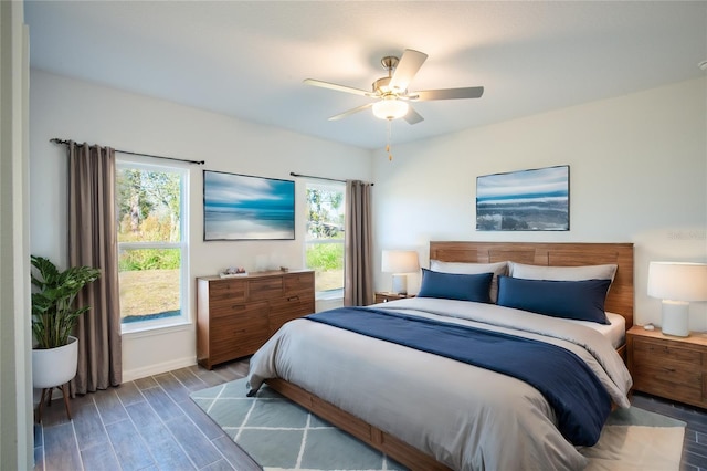 bedroom with wood-type flooring, multiple windows, and ceiling fan