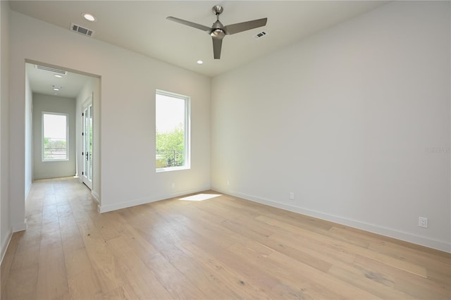 empty room with ceiling fan and light hardwood / wood-style floors