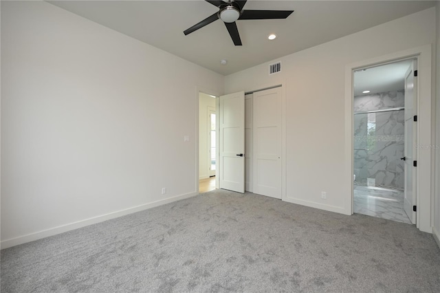 unfurnished bedroom featuring ensuite bathroom, ceiling fan, and light colored carpet