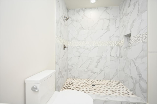 bathroom with toilet and a tile shower