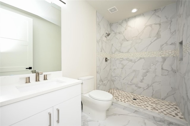 bathroom featuring vanity, toilet, and tiled shower