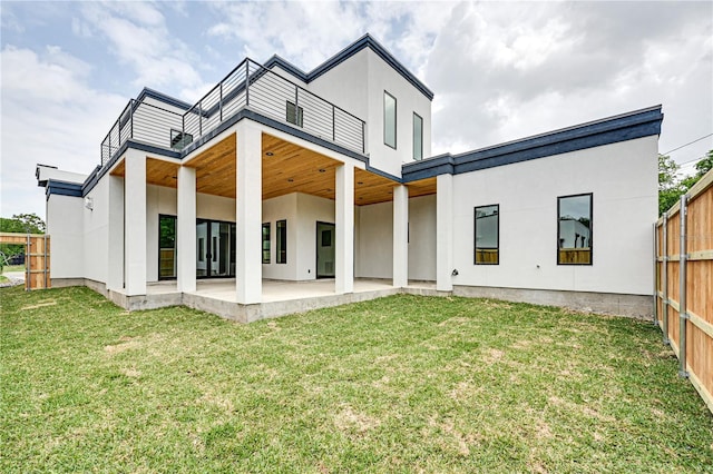 back of house with a lawn, a patio area, and a balcony