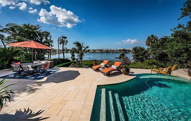 view of swimming pool featuring a patio area and a water view