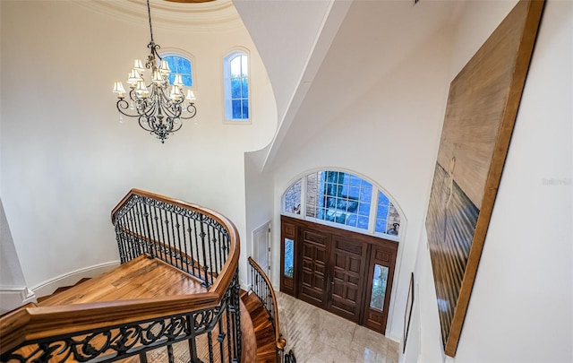 entrance foyer featuring a towering ceiling and an inviting chandelier