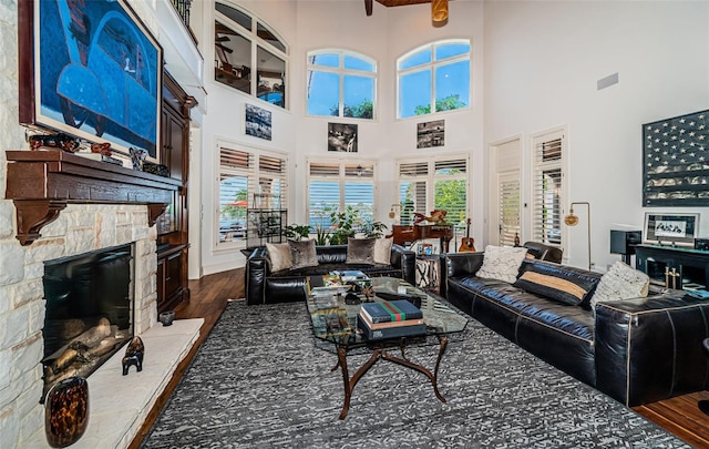 living room with a fireplace, a high ceiling, and dark hardwood / wood-style flooring