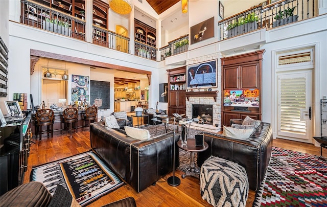 living room featuring hardwood / wood-style flooring, a high ceiling, wood ceiling, and a fireplace