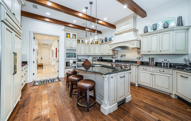 kitchen with a center island, decorative light fixtures, decorative backsplash, premium range hood, and dark hardwood / wood-style floors