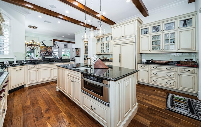 kitchen featuring a kitchen island, pendant lighting, tasteful backsplash, and cream cabinets