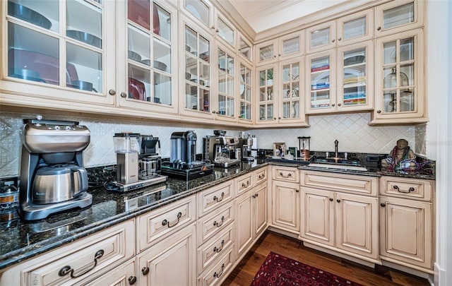 kitchen featuring sink, dark stone countertops, dark hardwood / wood-style flooring, and decorative backsplash