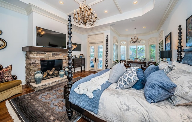 bedroom with a fireplace, dark wood-type flooring, a chandelier, and french doors