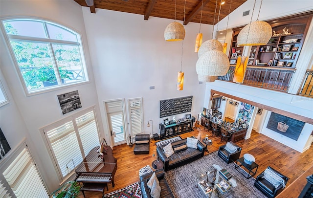 living room with wood-type flooring, wooden ceiling, beamed ceiling, and a high ceiling