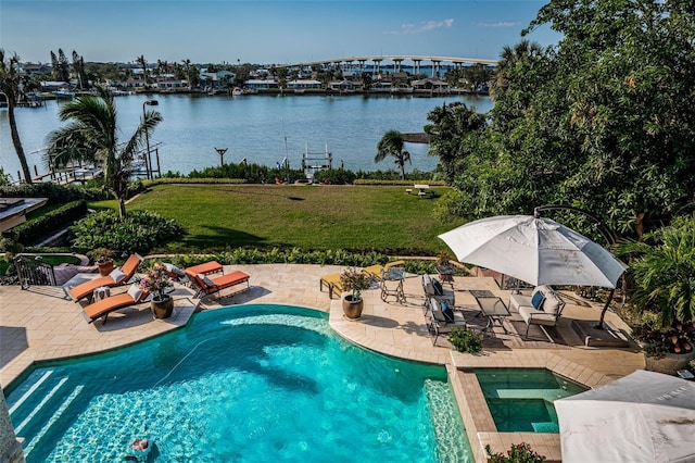 view of swimming pool featuring a patio, a water view, and a lawn