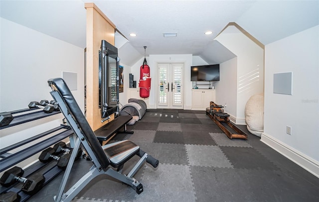 exercise room with french doors, a textured ceiling, and lofted ceiling