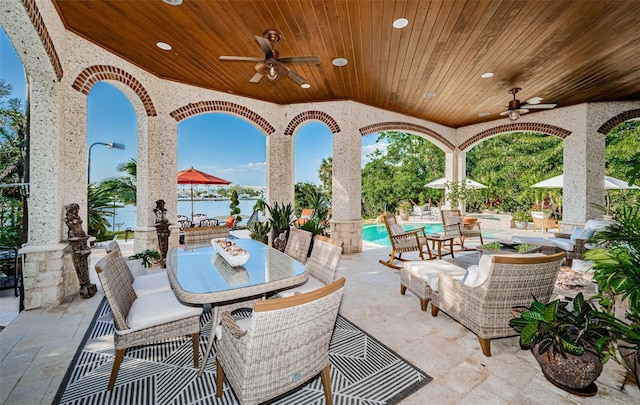 view of patio / terrace with an outdoor living space, ceiling fan, and a water view