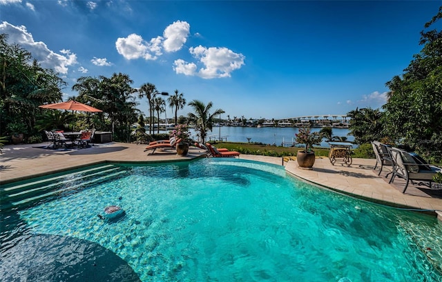 view of swimming pool with a water view and a patio