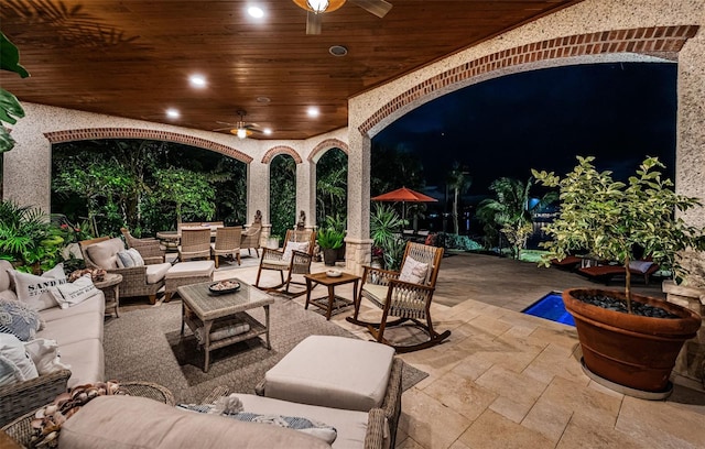 patio at night with ceiling fan and outdoor lounge area