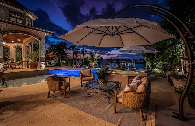 patio terrace at dusk with a pool with hot tub