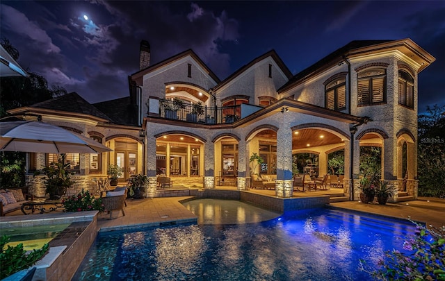 pool at twilight featuring a patio