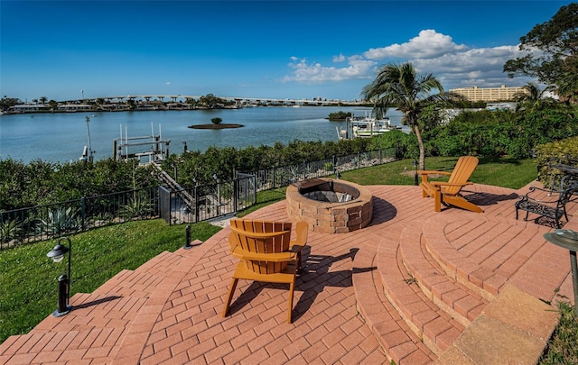 view of patio with a fire pit and a water view