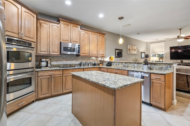 kitchen featuring pendant lighting, a center island, light stone countertops, kitchen peninsula, and stainless steel appliances