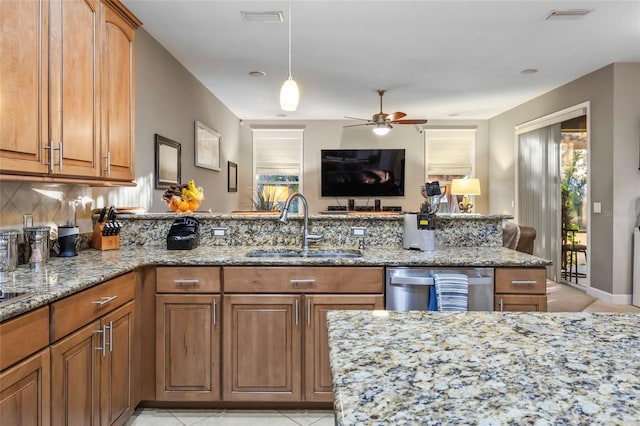 kitchen featuring ceiling fan, dishwasher, sink, light stone counters, and light tile patterned flooring