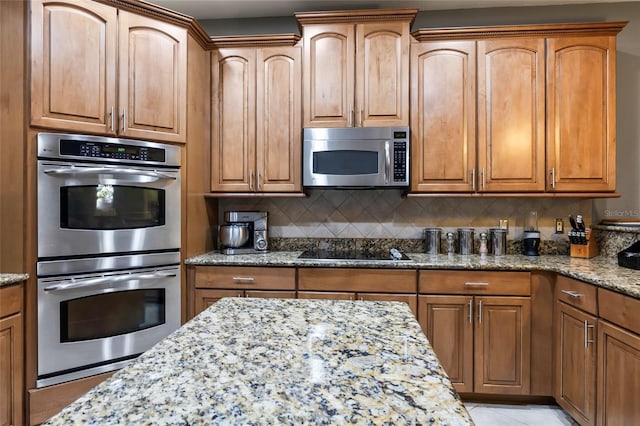 kitchen with light stone counters, light tile patterned floors, appliances with stainless steel finishes, and tasteful backsplash