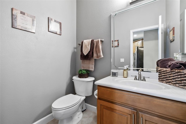 bathroom featuring toilet, vanity, and tile patterned floors