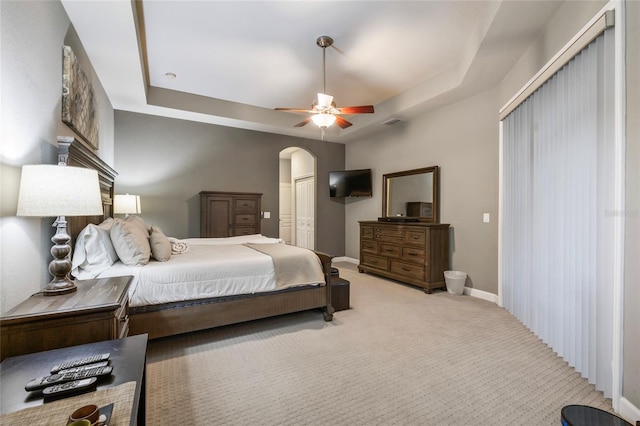 bedroom featuring carpet flooring, ceiling fan, and a tray ceiling