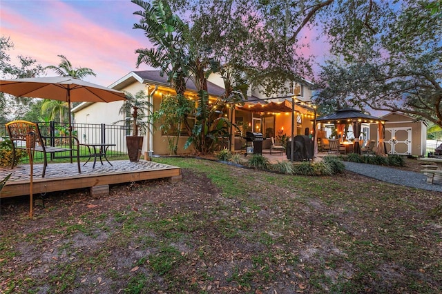 yard at dusk with a gazebo and a wooden deck