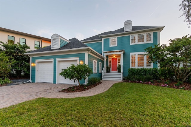 colonial inspired home with a garage and a front lawn